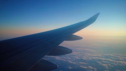 Obraz premium Aerial view from an airplane wing during sunset, showcasing clouds and sky.