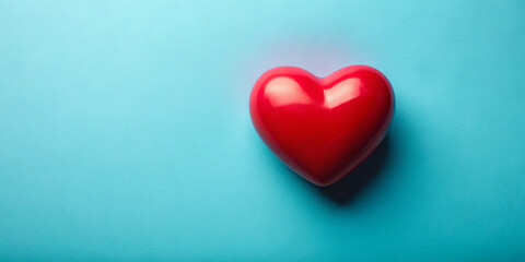 Fototapeta premium A heart-shaped red object sits centered on a smooth blue surface, conveying feelings of love and warmth. The simple composition highlights the symbolism of affection