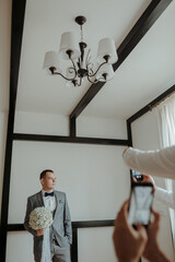 A woman is getting ready for a wedding, and she is standing in front of a dresser with a wedding...