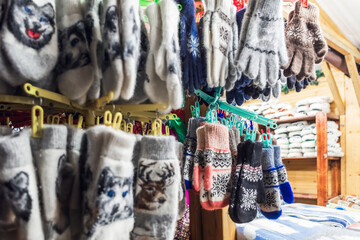 Colorful and warm knitted gloves and mittens on display at a market stall