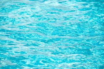 Background of blue water in swimming pool with sun reflection, ripple water wave in pool. Clear water background.