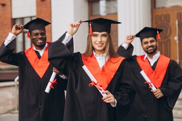 Happy Group of Diverse Students Celebrating Graduation with Diplomas Outdoors