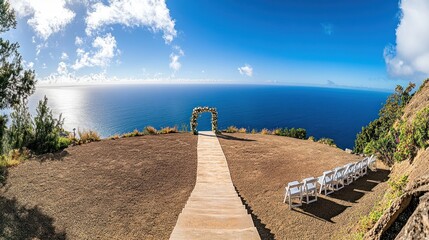 Fototapeta premium Scenic outdoor wedding venue overlooking the ocean with a pathway and seating.