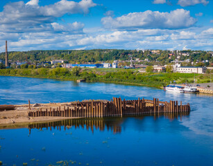 Construction site of new modern bridge construction in Kaunas, Lithuania. Aerial drone view of bridge connecting two shores of a river. Work progress