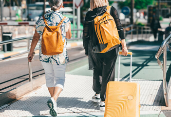 Back view of two Mature Caucasian women in airport parking walking towards terminal. Modern female...