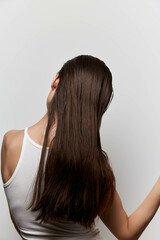 Fototapeta premium Long, shiny hair of a young woman against a minimalistic white background, showcasing hair textures and movement, emphasizing beauty and health concepts effectively