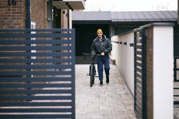 Man Going Out of the House With a Bicycle