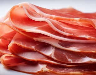 A macro shot of a stack of thinly sliced cured meats like prosciutto, showing the marbled f