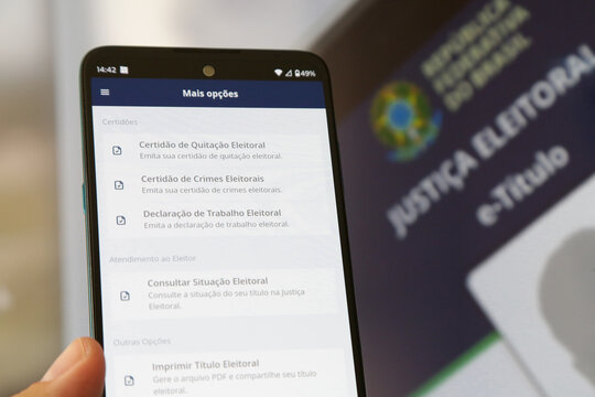 Aplicativo E titulo para elei&ccedil;&otilde;es com fundo desfocado.