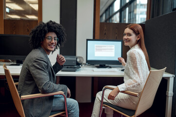 Young man and young woman working together on the project in the office