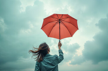 girl with red umbrella against sky background, view from back