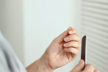 Naklejka premium Close up of woman doing her nails at home, natural manicure 