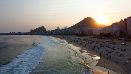 Foto deslumbrante do pôr do sol na Praia de Copacabana, Rio de Janeiro, com o céu colorido...