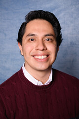 portrait of a happy latin man with wine color sweater yearbook style