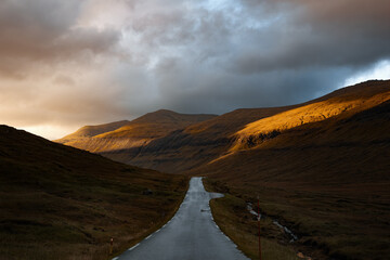 Scenic sunset over a road in the mountains of Faroe islands