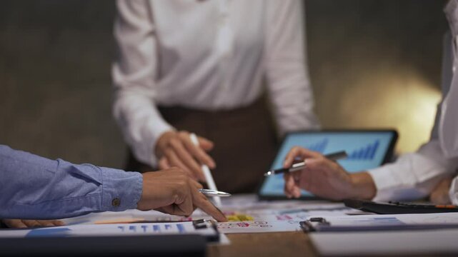 Business team members discussing and analyzing financial data on a tablet during a collaborative meeting in the office