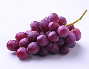 Fototapeta premium A bunch of purple grapes with one separate grain, focus on the skin texture isolated on white background