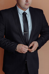 A woman is getting ready for a wedding and is putting on her jewelry. The mirror reflects her as she does so