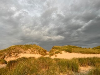 Obraz premium Dune panorama on the North Sea with a restless, gloomy sky