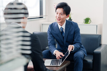 得意先と商談をするスーツを着たビジネスマン