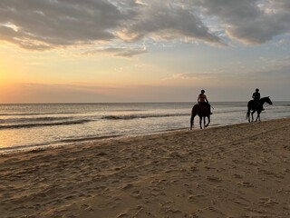 Two riders in the evening sun on the beach