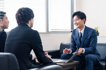 得意先と商談をするスーツを着たビジネスマン