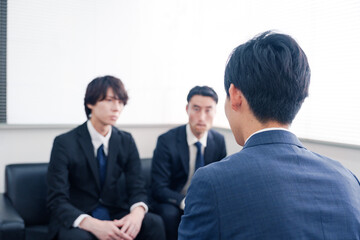 得意先と商談をするスーツを着たビジネスマン