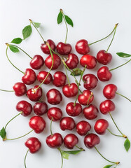 A bunch of red cherries with green stems, neatly arranged in the middle of a white background