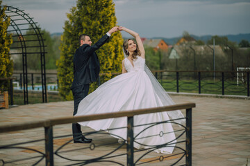 A woman in a wedding dress stands in front of a window. She is wearing a veil and a tiara