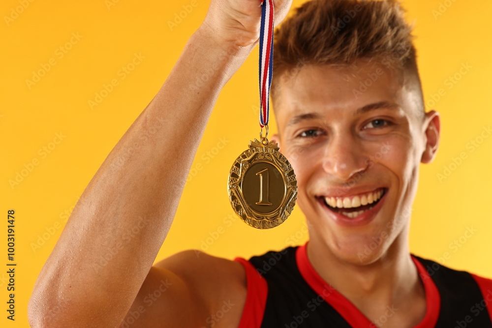 Poster Happy winner with golden medal on yellow background, selective focus