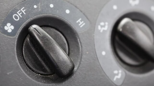 Handheld Tight Shot Of Car Dashboard Controls For Air Flow And Fan
