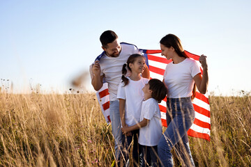 Happy family with flag of USA outdoors. Space for text © New Africa