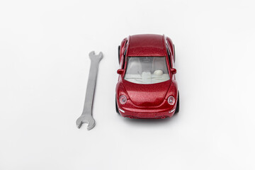 Red toy car and wrench. Car repair at car service station
