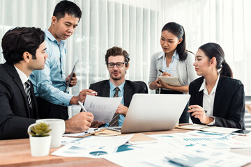 Diverse group of business analyst team analyzing financial data report paper on office table. Chart and graph dashboard by business intelligence analysis for strategic marketing planning Meticulous