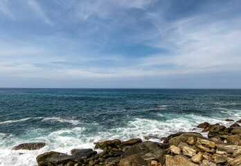 Background themes: Waves breaking on the rocks on a tropical beach.