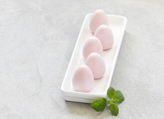 Raspberry cream mousse eggs. With mint.  Close-up	