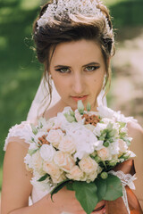 Naklejka premium A woman is holding a bouquet of flowers and wearing a tiara. She has a beautiful smile on her face