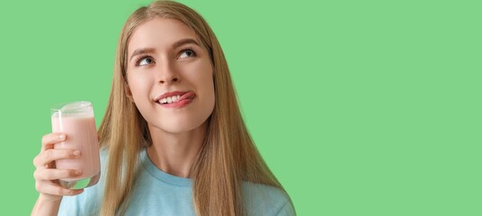 Young woman holding glass of tasty yogurt on green background with space for text