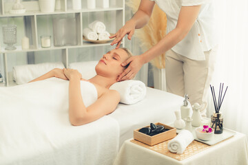 Obraz premium Caucasian woman enjoying relaxing anti-stress head massage and pampering facial beauty skin recreation leisure in dayspa modern light ambient at luxury resort or hotel spa salon. Quiescent
