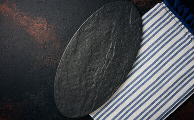 Oval stone kitchen board on black background, top view