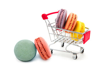 Shopping supermarket cart with colorful varied assortment macarons cookies isolated on a white...