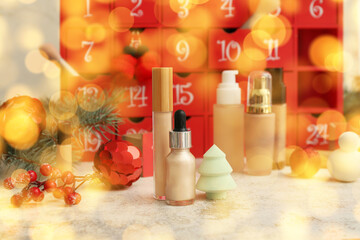 Different cosmetic products, advent calendar and Christmas decor on table