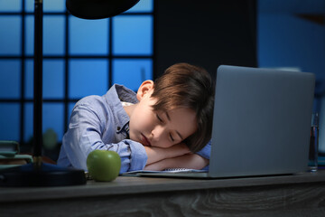 Little boy sleeping at table late in evening