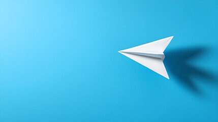 A light blue background with a floating paper airplane casting a shadow below. Paper airplane on a blue background.


