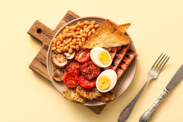 Plate of tasty English breakfast with boiled egg on yellow background
