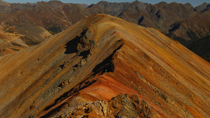 Person hiking on colorful Red Mountain in Colorado, USA