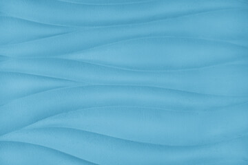 Plaster wall with volumetric relief surface wavy form pattern, blue gypsum texture panel.