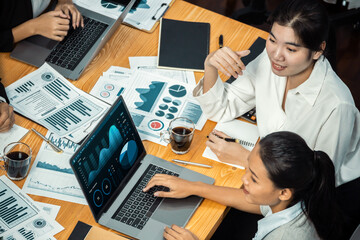 Wide top view of diverse group of business analyst team analyzing financial data report paper on...