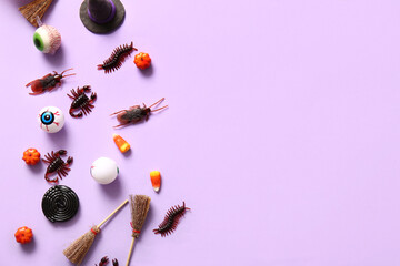 Halloween composition with candy bugs, eyeballs and brooms on lilac background
