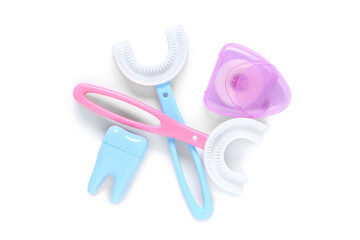 Children's toothbrushes with dental floss and tooth model on white background